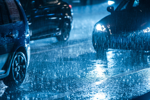 Car driving in rain at night
